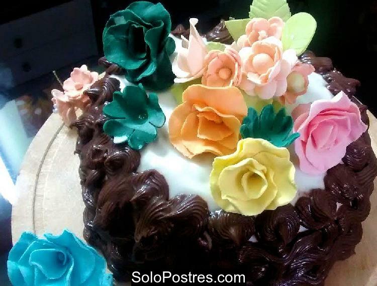 Torta de cumpleaño decorada con ganache y rosas de varios colores